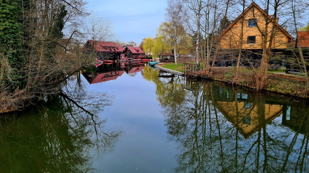 Spreewald-Fließ in Lübben mit Holzhäusern am Ufer und ruhigem Wasser.
